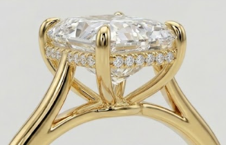 Gold engagement ring with a large cushion-cut diamond center stone and accent diamonds hidden around the basket