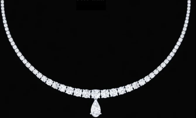Diamond necklace with square-cut diamonds and a teardrop-shaped diamond pendant on black background