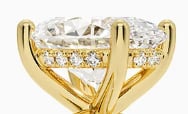 Gold engagement ring with large cushion-cut diamond and diamond-accented band
