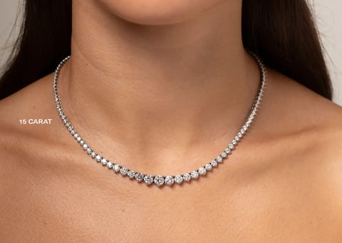 Woman wearing a 15 carat diamond tennis necklace on a neutral background
