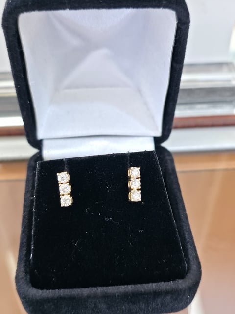 Pair of diamond stud earrings in a black velvet jewelry box with white lining