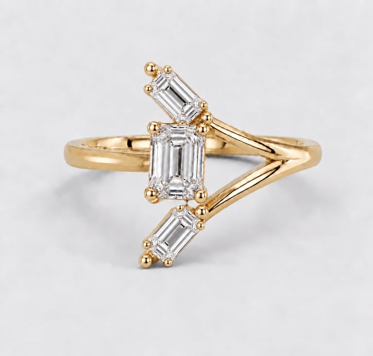 Gold ring with geometric design featuring emerald-cut diamonds arranged in a chevron pattern on white background