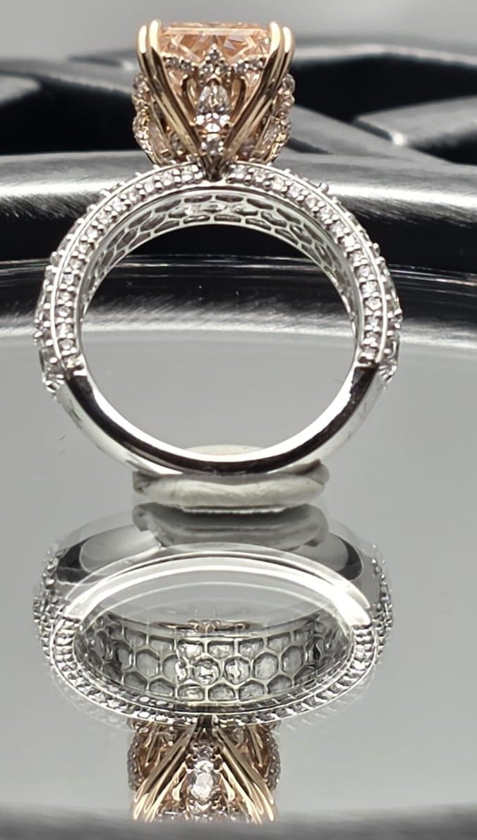 Elegant diamond engagement ring with ornate white metal band and champagne-colored stone, shown from front and back views