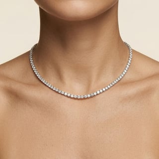 Man wearing a diamond tennis necklace against a neutral background