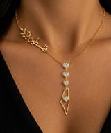 Woman wearing gold necklaces with Hebrew text pendant and heart-shaped crystal pendant with map-shaped charm