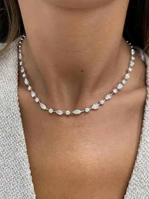 Woman wearing a diamond tennis necklace with round and oval cut stones