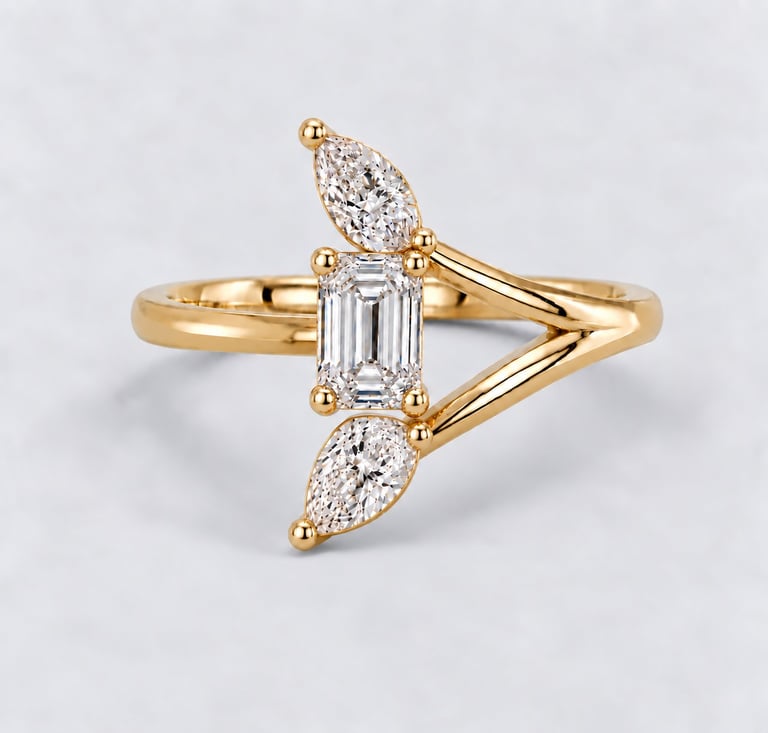 Gold ring with emerald-cut diamond center stone and marquise-cut diamond accents on white background