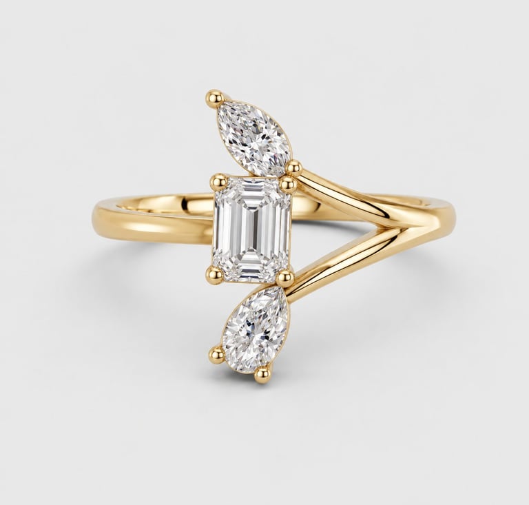 Gold engagement ring with emerald-cut diamond center stone flanked by marquise-cut diamonds