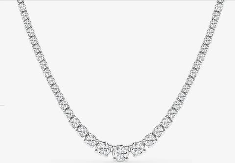 Diamond tennis necklace with round brilliant cut stones set in white metal on light background