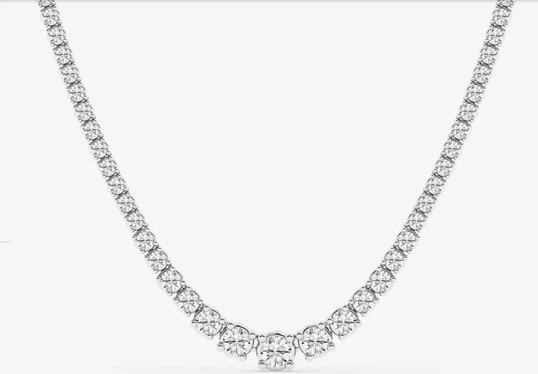 Diamond tennis necklace with round brilliant cut stones set in white metal on light background