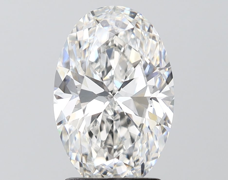 Close-up of a large oval-cut diamond with brilliant facets and sparkle on a gray background